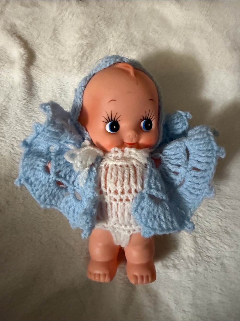 This is a vintage vinyl Kewpie doll wearing a handmade crocheted outfit.